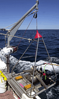 Photograph of small USGS SEABOSS grab sampler being deployed at sea.